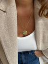 The Amour Necklace from AB Paris features a round golden pendant inscribed with "Amour," symbolizing love and affection.