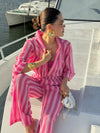 Plush pink bikini set paired with striped Marta pants and a poncho for an effortlessly chic resort outfit.