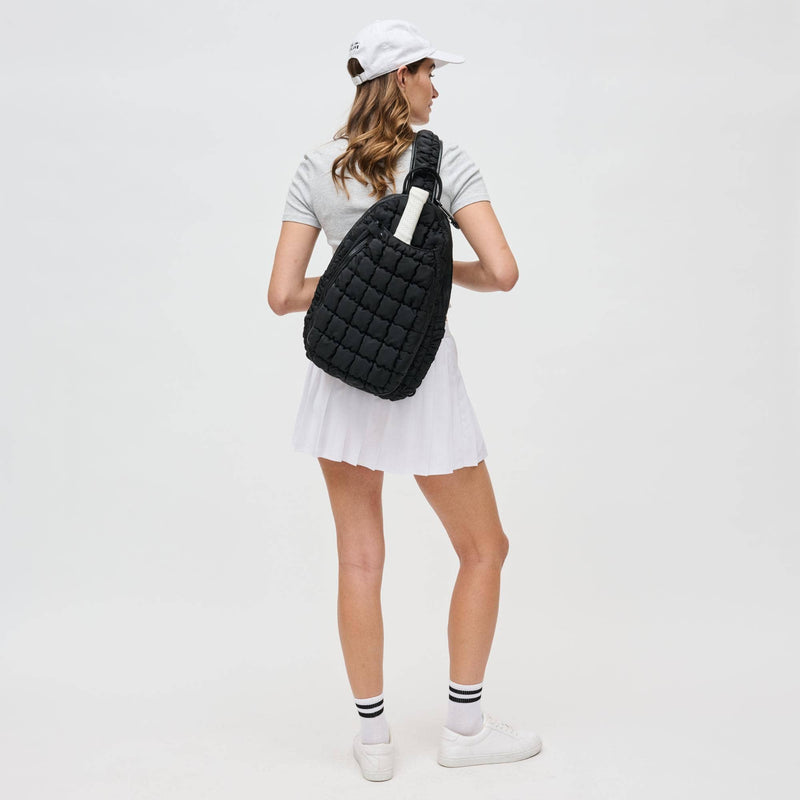 Sol and Selene Quilted Puffer Sling Backpack in black nylon with quilted design, adjustable strap, and zippered compartments.